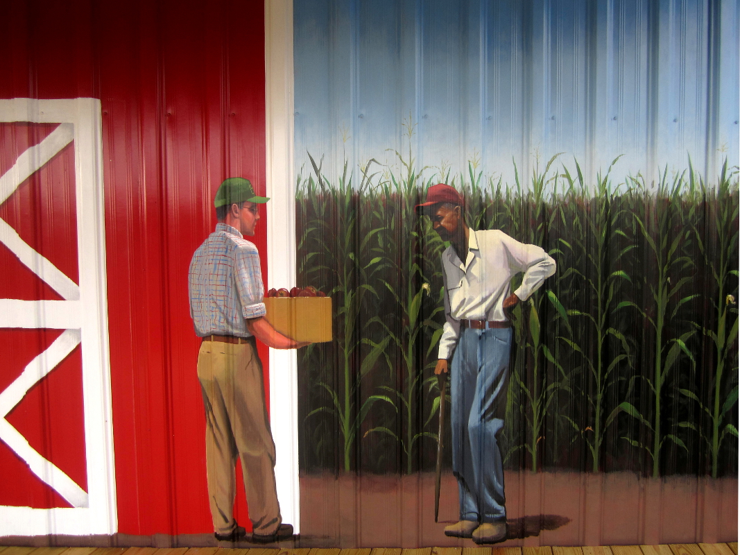 Lenoir County farmer's Market mural, Kinston NC. Detail of farmers with apples in front of the corn field by North Carolina artist, Jeremy Sams.